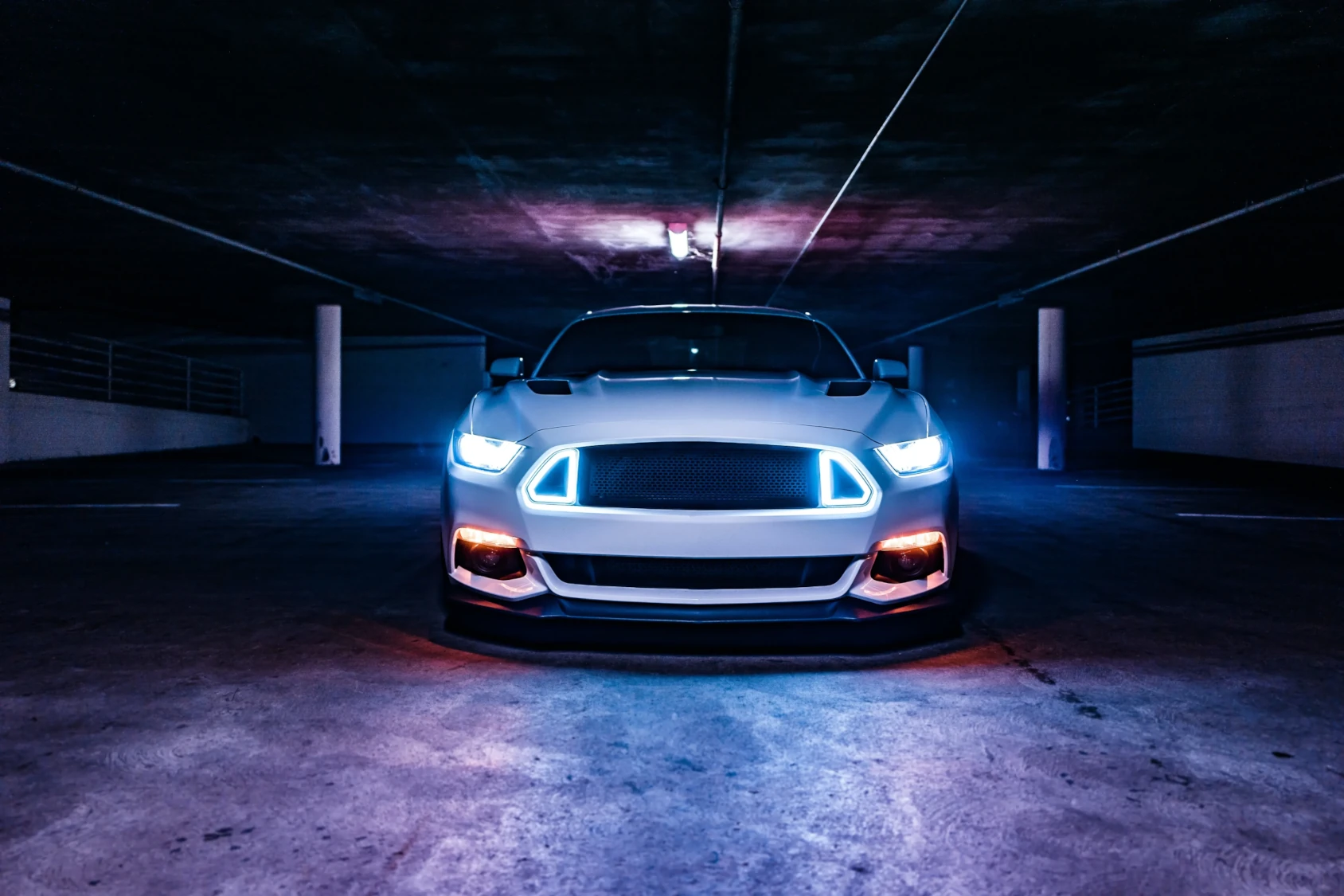 Silver performance car illuminated in a dark garage